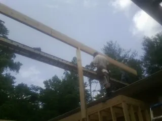 Carpenter setting a ridge beam over a new addition frame — Ice Dam Removal by Roofing Brothers in Willet