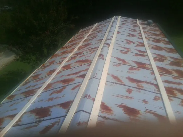 Rusted metal roof panels with new wood purlins before replacement — Storm Damage Roof Repair in Willet by Roofing Brothers