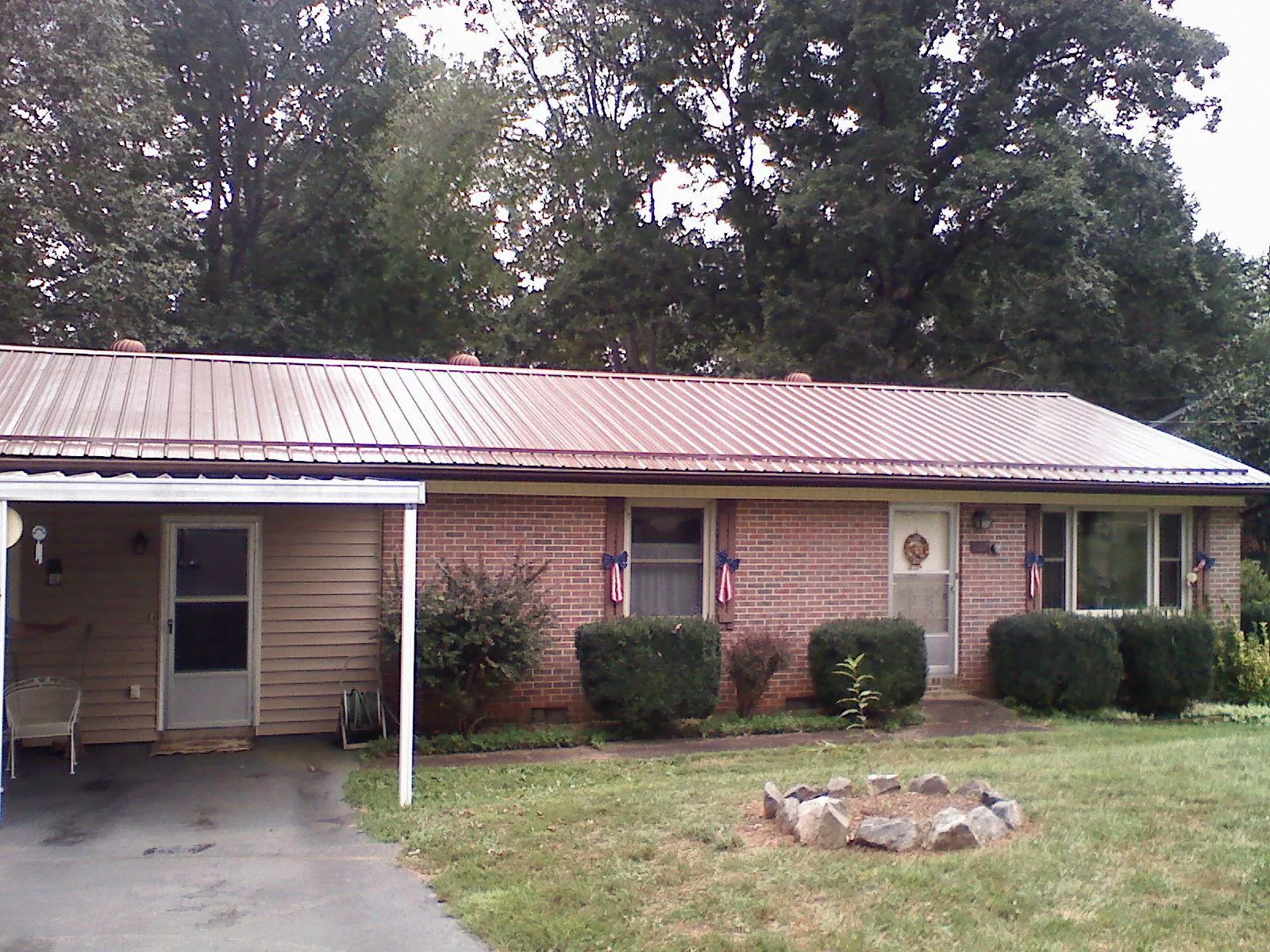 Bronze metal roof and carport on a brick ranch home — Roof Repair work by our crew in Willet